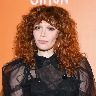 Natasha Lyonne wears voluminous medium-length curly hair with bangs at the 2018 Trevor Project TrevorLIVE NYC event