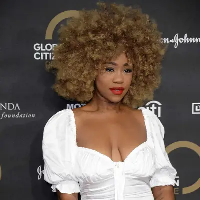 Chidera Eggerue with golden blonde curls and bangs at the 2019 Global Citizen Prize event in London, England