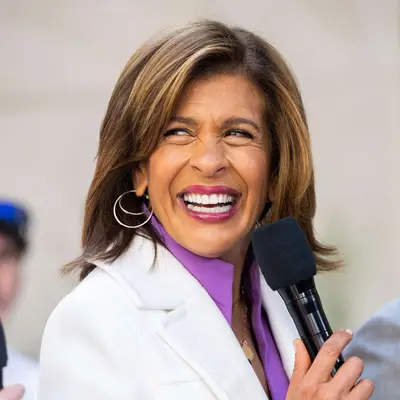 Hoda Kotb smiling and holding a microphone