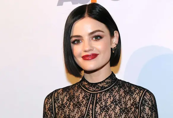 Actress Lucy Hale with a bob haircuit, red lipstick, and a lace top