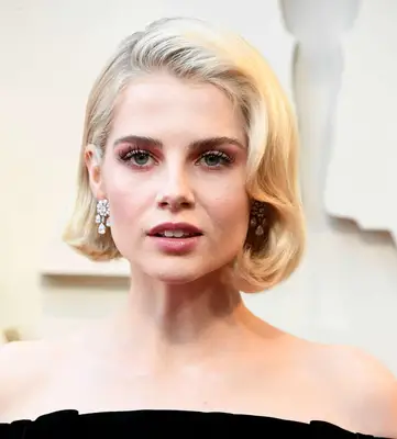 Lucy Boynton wears a wavy blonde bob hairstyle