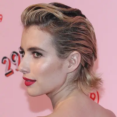 Emma Roberts wears a slicked-back short hairstyle