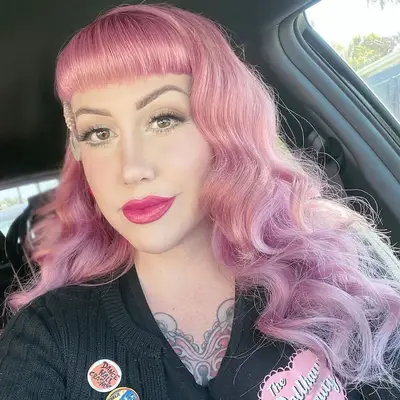 Woman with pink hair with Bettie Page bangs