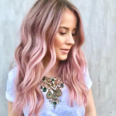 Nikki Lee in white t-shirt and statement necklace with classic wavy Rose Gold Hair