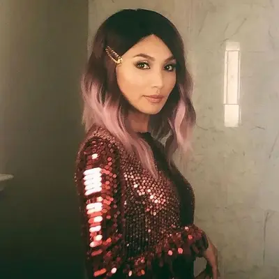 Gemma Chan in red sequin dress with rooted rose gold hair