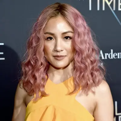 Constance Wu in yellow dress with Cotton Candy Rose Gold Hair