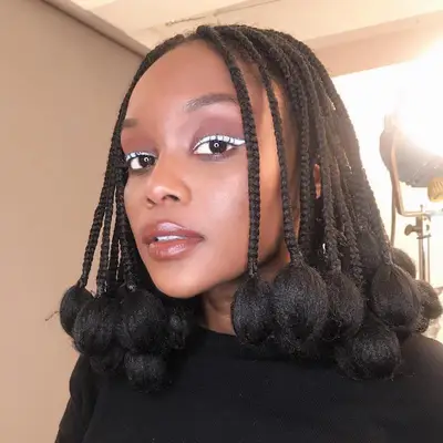 Music artist Falana wears a Fulani braided bob hairstyle with puffed ends