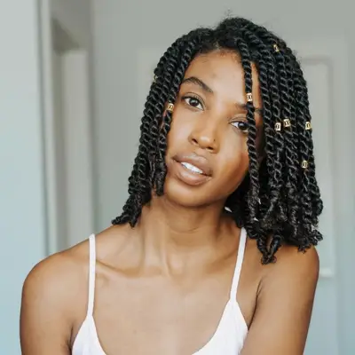 Woman in tank top with twisted bob hairstyle and gold charms