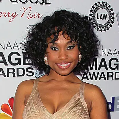 Angell Conwell wears a voluminous curly bob hairstyle