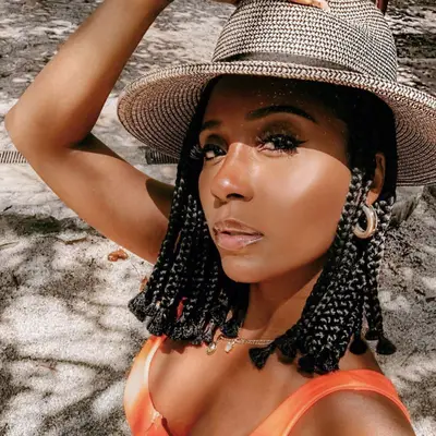 Woman on beach with braided bob hairstyle in a brimmed hat