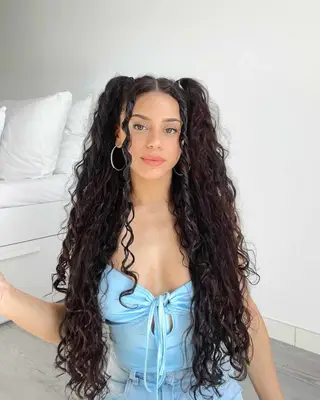 Alyssa Lloyd with curly half up half down pigtails