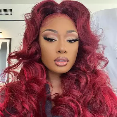 megan thee stallion wearing red hair in a half up half down style