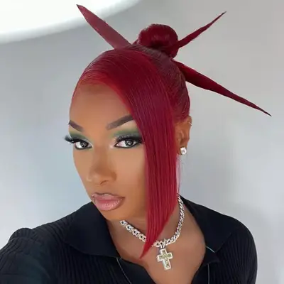 megan thee stallion wearing a red spiky bun