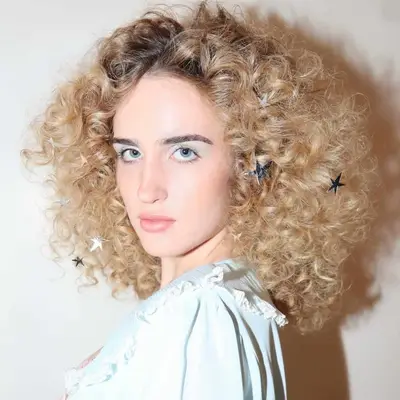woman with blonde curly hair with stars in her hair