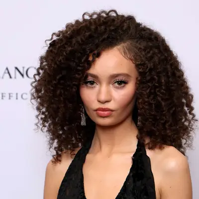 Actor Nico Parker with curly hair and a bang to the right