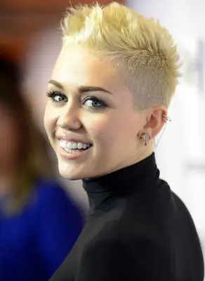 Miley Cyrus with a spiked blonde buzz cut on the red carpet