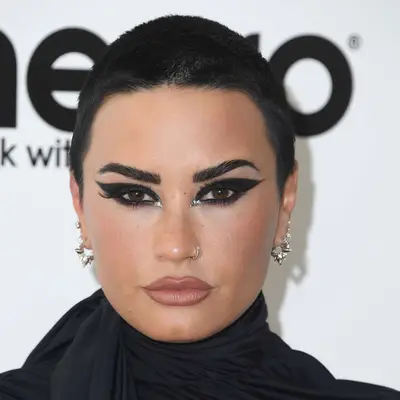 Demi Lovato with jet-black buzz cut and graphic eyeliner