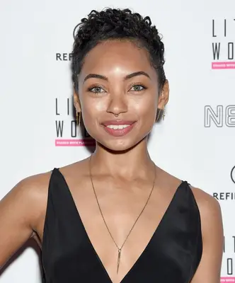 Logan Browning with a short, curly pixie hairstyle on the red carpet