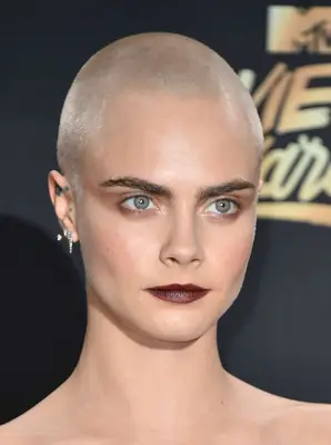 Cara Delevigne with a platinum blonde shaved hairstyle on the red carpet
