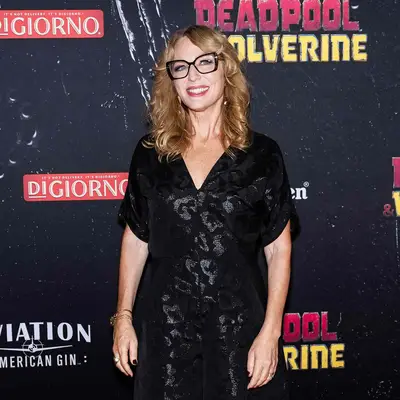 Sarah Finn wearing large chunk dark glasses with curled hair