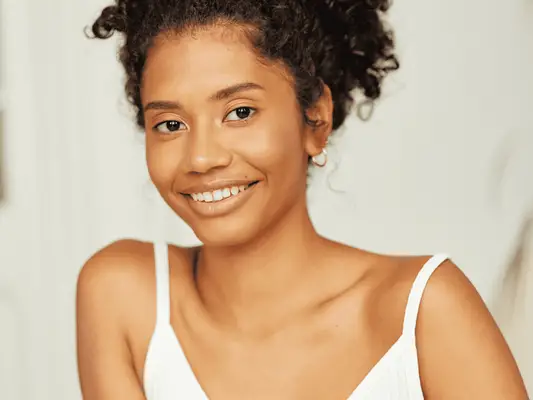 A woman with her hair pulled back and clear, glowing skin