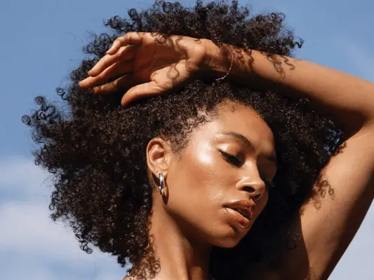 woman touching hair against blue background
