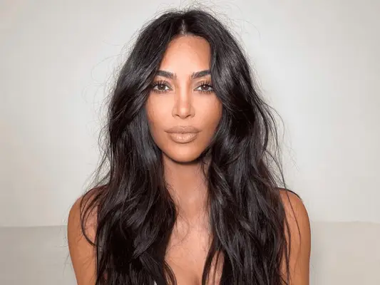 kim kardashian with messy long hair against white background