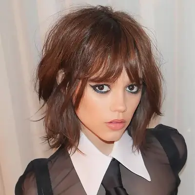 Halle Berry with short hair in a light blouse, facing forward