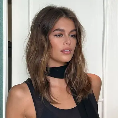 Kaia Gerber with wavy brown balayage hair