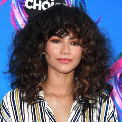 Zendaya with curly dark black and brown balayage hair at the 2017 Teen Choice Awards in Los Angeles