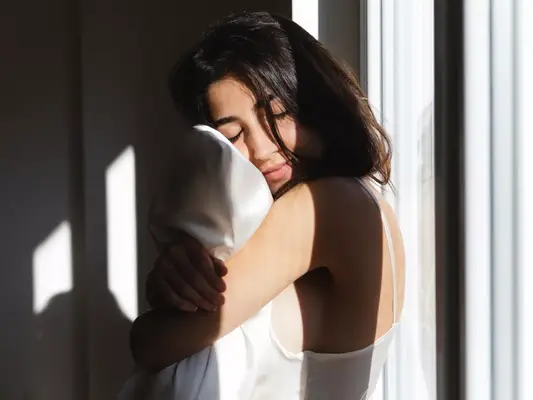 woman hugging satin pillow