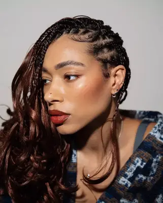 a woman in profile with knotless box braids with french curl ends