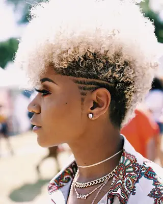 Woman with blonde curly fauxhawk and undercut
