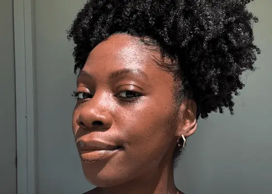 close up of woman with coily hair in bun