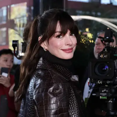 Anne Hathaway with bangs and a ponytail.