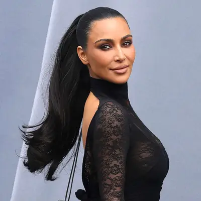 Kim Kardashian attends Paris Fashion Week in a thick and flirty mid-height ponytail against an open back top