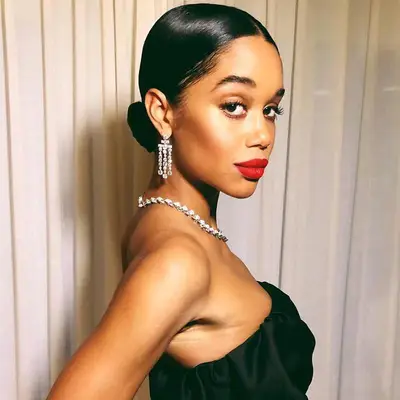 Laura Harrier wears a sleek low chignon updo