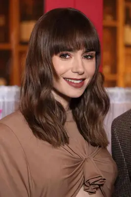 Lily Collins with a wavy shag hairstyle and soft fringe