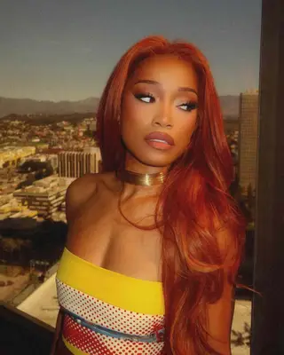 Keke Palmer with long, layered copper red waves