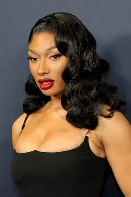 Megan Thee Stallion wearing side-parted long wavy sew-in