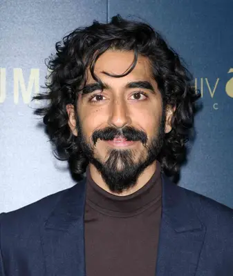 Actor Dev Patel with curly hair and bangs 