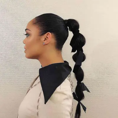 Tessa Thompson in side profile, her hair in a bubble ponytail