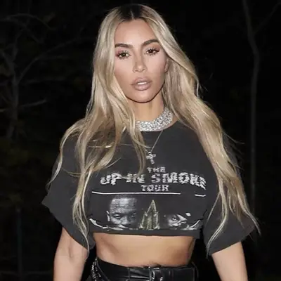 Kim Kardashian with long blonde hair and brown roots