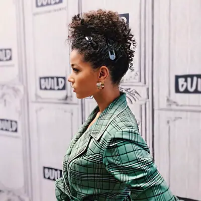 Alisha Wainwright looking off to the side and her hair in a curly updo with clips