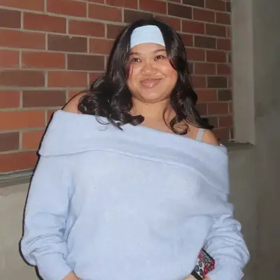 Back view of a French twist hairstyle with large white claw clip and face-framing tendril