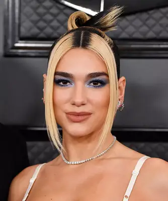 Dua Lipa with architectural bun and blonde face-framing pieces