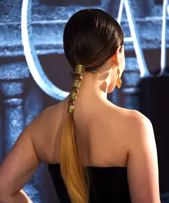 Low ponytail wrapped with gold cord