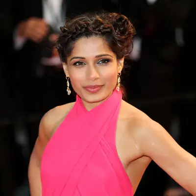 Frieda Pinto with crown braid updo and pink dress attends the Opening Ceremony and premiere of 