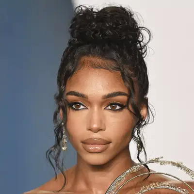 Lori Harvey with curly undone updo attends the 2022 Vanity Fair Oscar Party