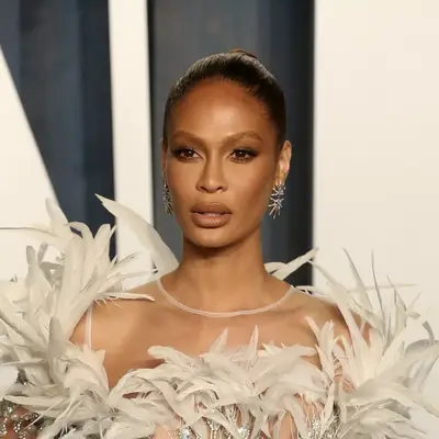 Joan Smalls with slicked-back hair and feathered dress attends as David Yurman Celebrates The Vanity Fair Oscar Party